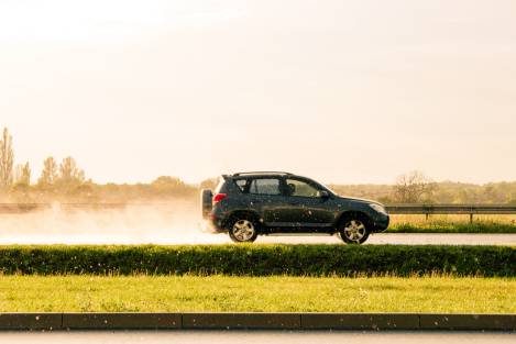 SUV driving in the rain at golden hour