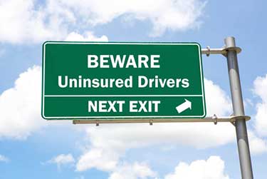 Road sign saying beware uninsured drivers 