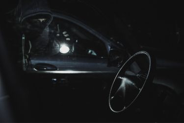 person shining flashlight inside car