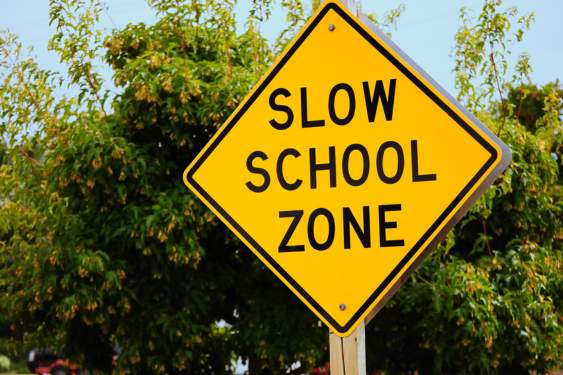 yellow slow down sign in a school zone