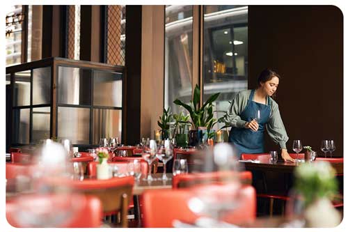 A waitress setting tables in restaurant