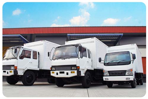 white cargo trucks being loaded for a delivery