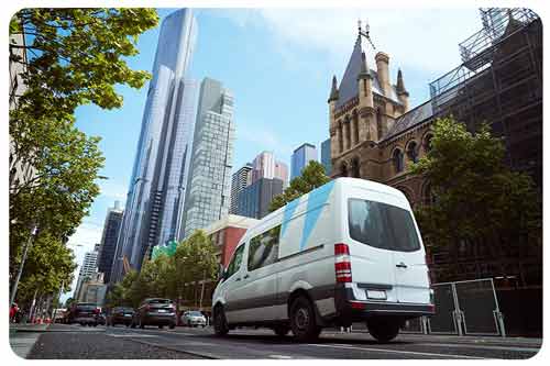 a commercial van on driving on a city street