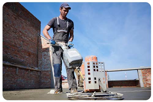 concrete contractor finishing concrete surface with floor screed grinder machine.