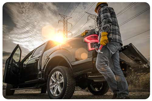 electrician with tools by truck near power lines, electrician insurance