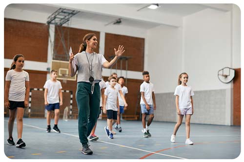trainer teaching talking to her students at gym.