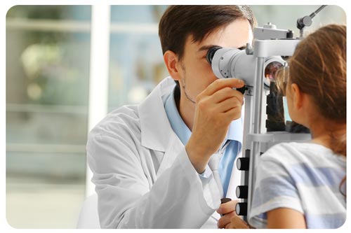 A male optician is examining the patient's eyes.