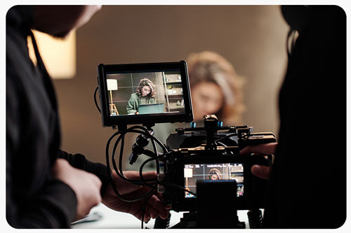 cameraman and assistant filming a woman in the studio.