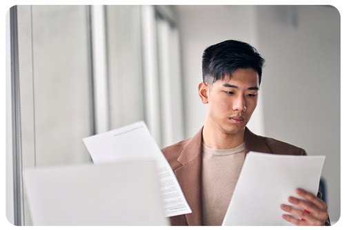 Young lawyer  holding paper documents in office.
