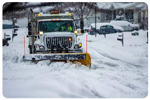 man using snowblower to clear snow on driveway 