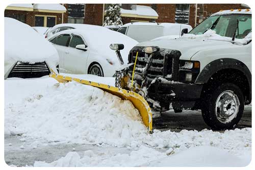 snowplow removes snow from parking lot