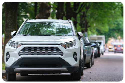 traffic with suv cars parked in line on street side.