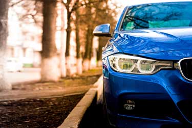 Blue BMW parked on side of road
