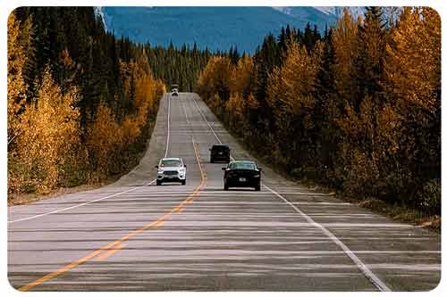 Cars driving with mountains in the background