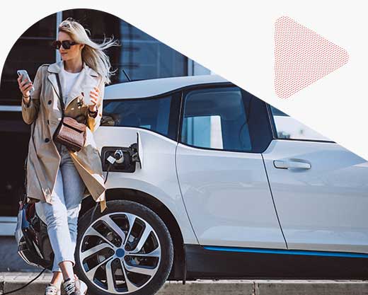 Women standing in front of electric car while it charges