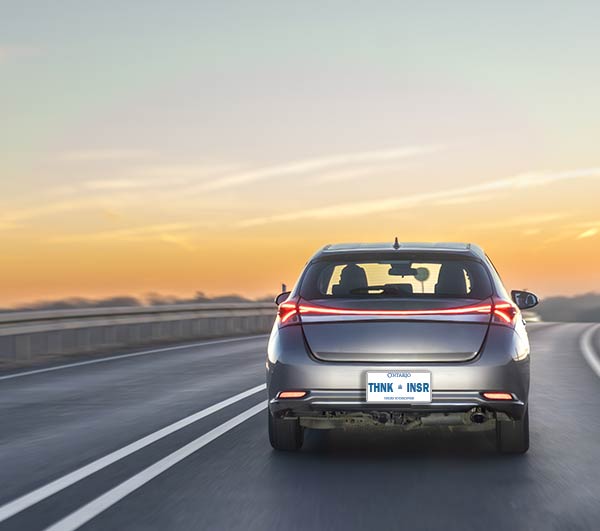  A car driving on a highway at sunset