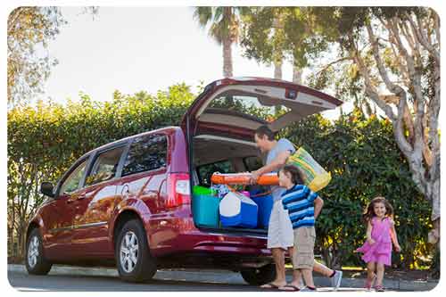 father loads personal belongings into minivan.