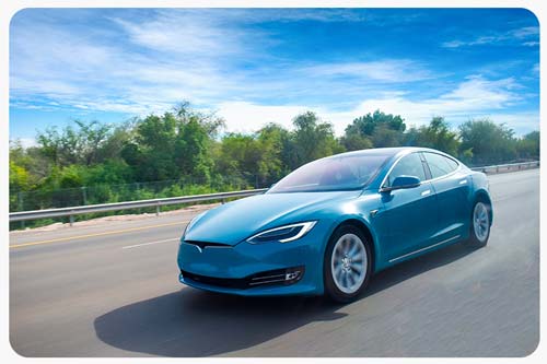 A blue tesla car cruising on highway