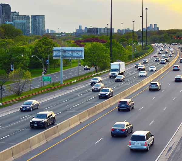 Cars and trucks travelling on a busy multi-lane highway.