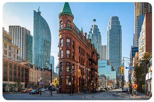 Cars are waiting for a traffic signal around Flatiron Building in downtown Toronto
