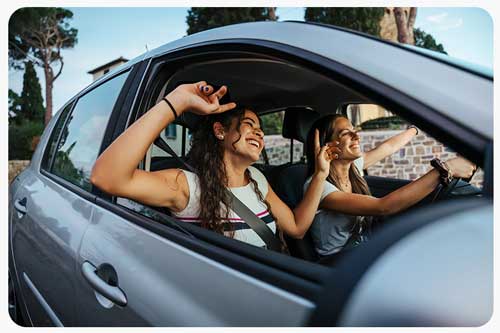 two young women having fun together driving around the countryside