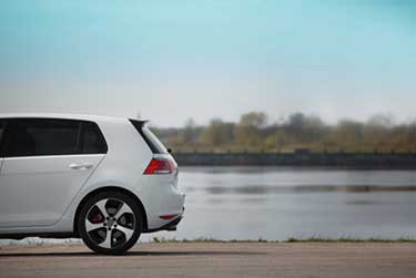 White Volkswagen Car parked beside the river