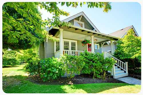 gray house with front porch and shrubs