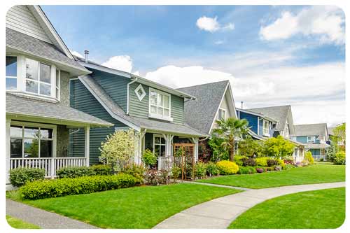 a row modern houses with well maintained front lawns.