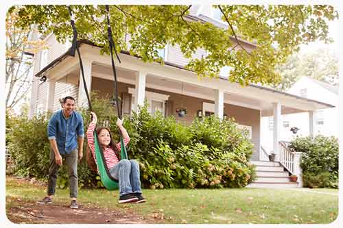 father and daughter on garden swing at home
