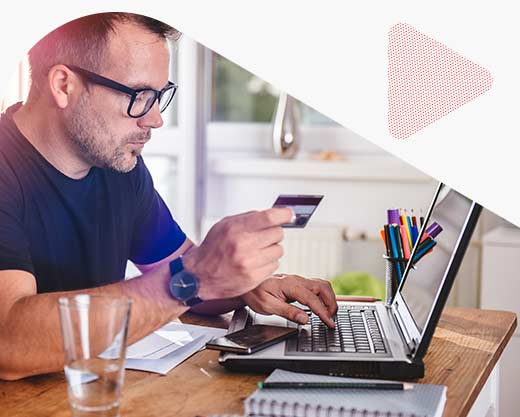 a man using credit card and laptop at home