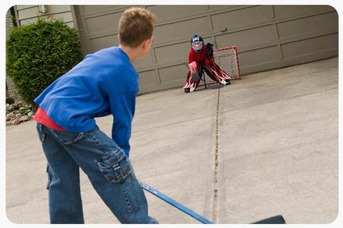 boys playing hocky on driveway