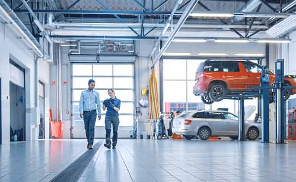 Car service employees talk in a garage
