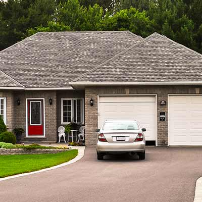 Grey car parked outside a house 