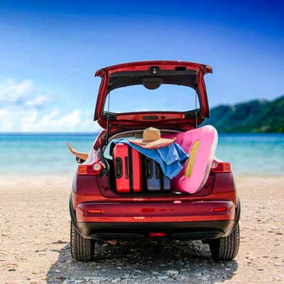 Red car with hatch open on a beach