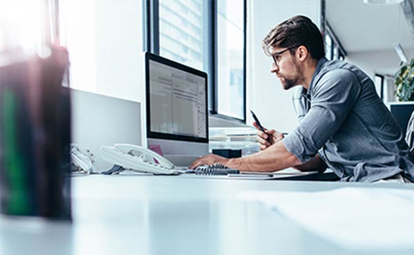 man sitting in office and working on desktop