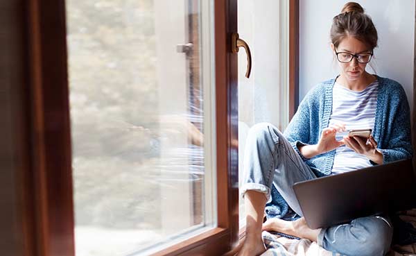 Young woman using laptop, phone and the Internet