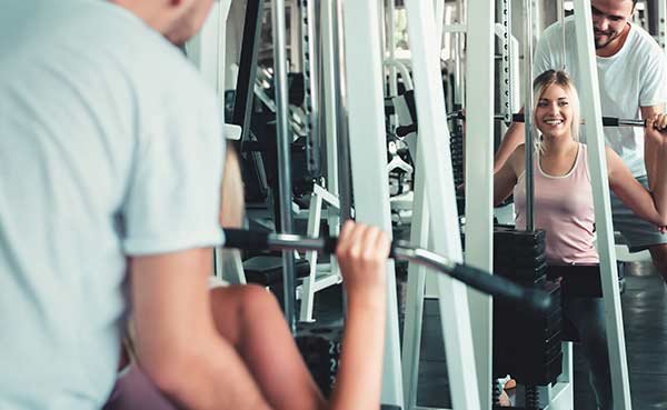 Woman is working out exercising with her trainer in gym