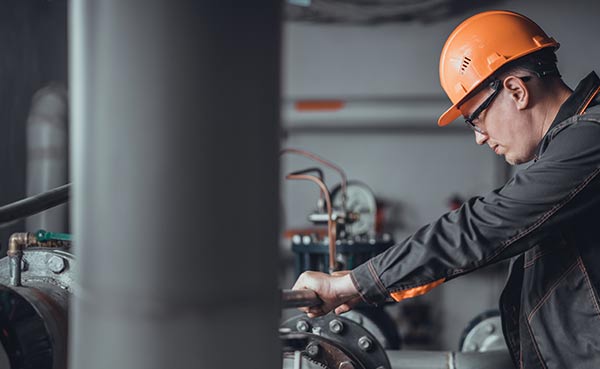 plumber inspecting popes in industrial building, plumbing insurance