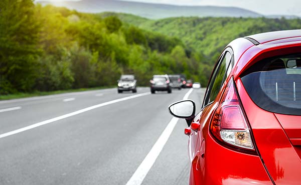 Red car on the side of the highway