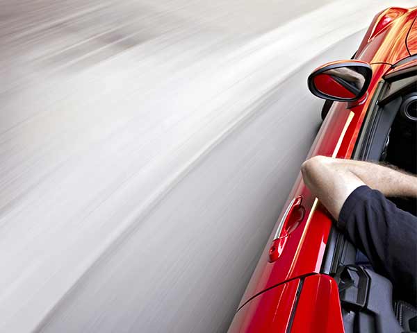 Red car driving on the 401 in Toronto