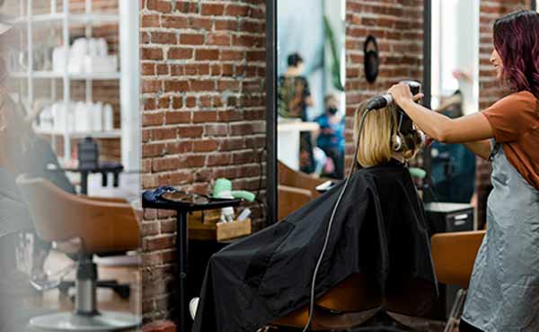 hairstylist giving a haircut to a customer at a salon