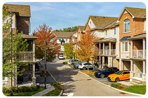 a woman and her dog are sitting in the shade in her backyard.