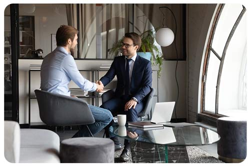 a client and insurance broker handshaking after deal