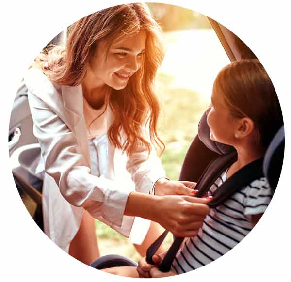 mother put her daughter in a car seat.