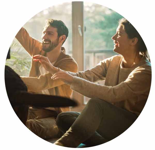couple play with their dog in the liveing room. 