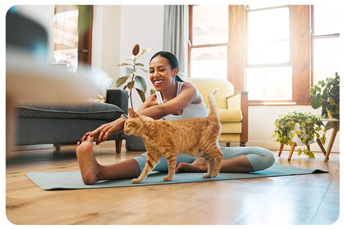 woman with her pet in yoga stretching in house.