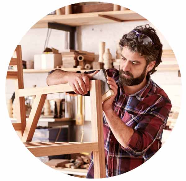 business owner sanding a chair frame.