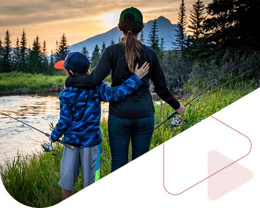 Brother and sister standing next to a creek while fishing in Alberta Canada at sunset