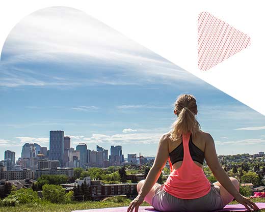 a girl practicing yoga in Calgary with the view of the city