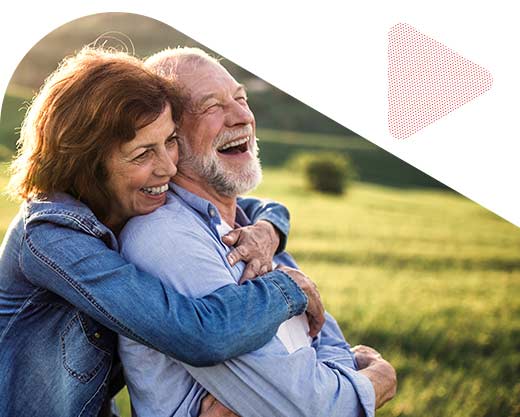 senior couple hugging outside in at sunset